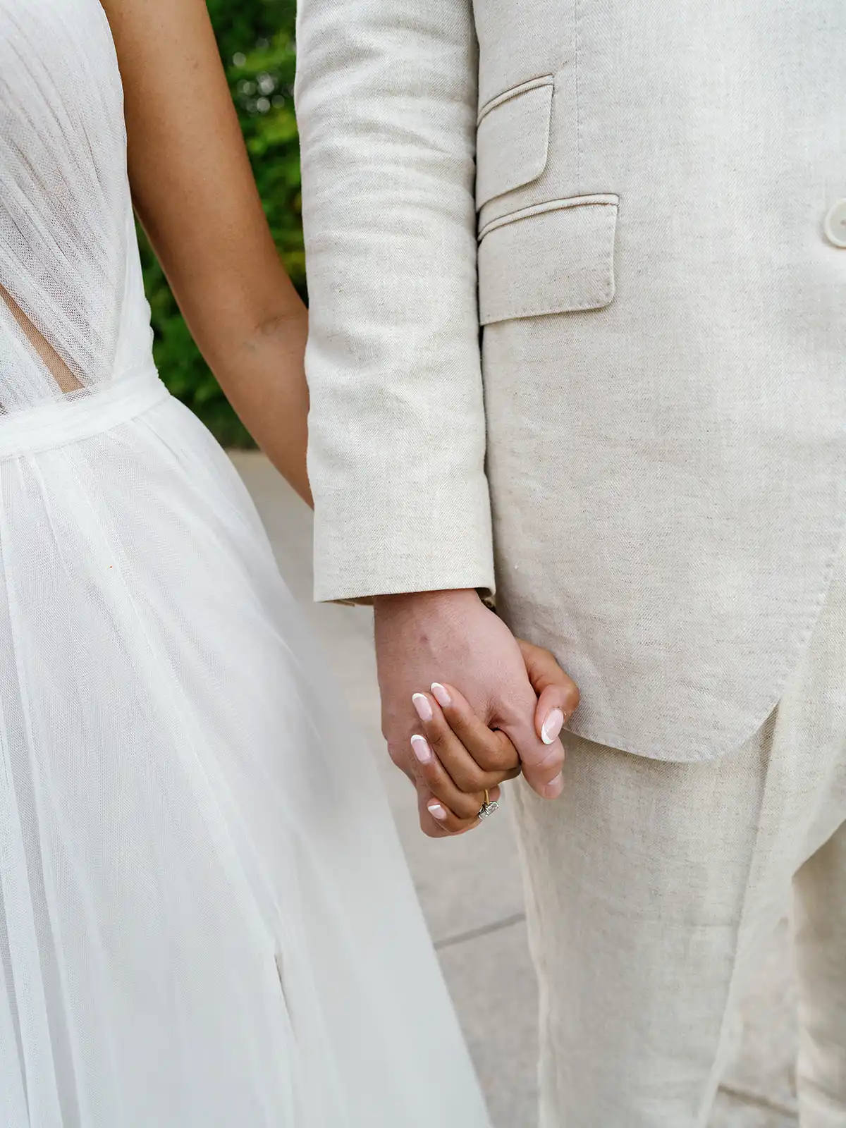 The couple holding hands on their wedding day