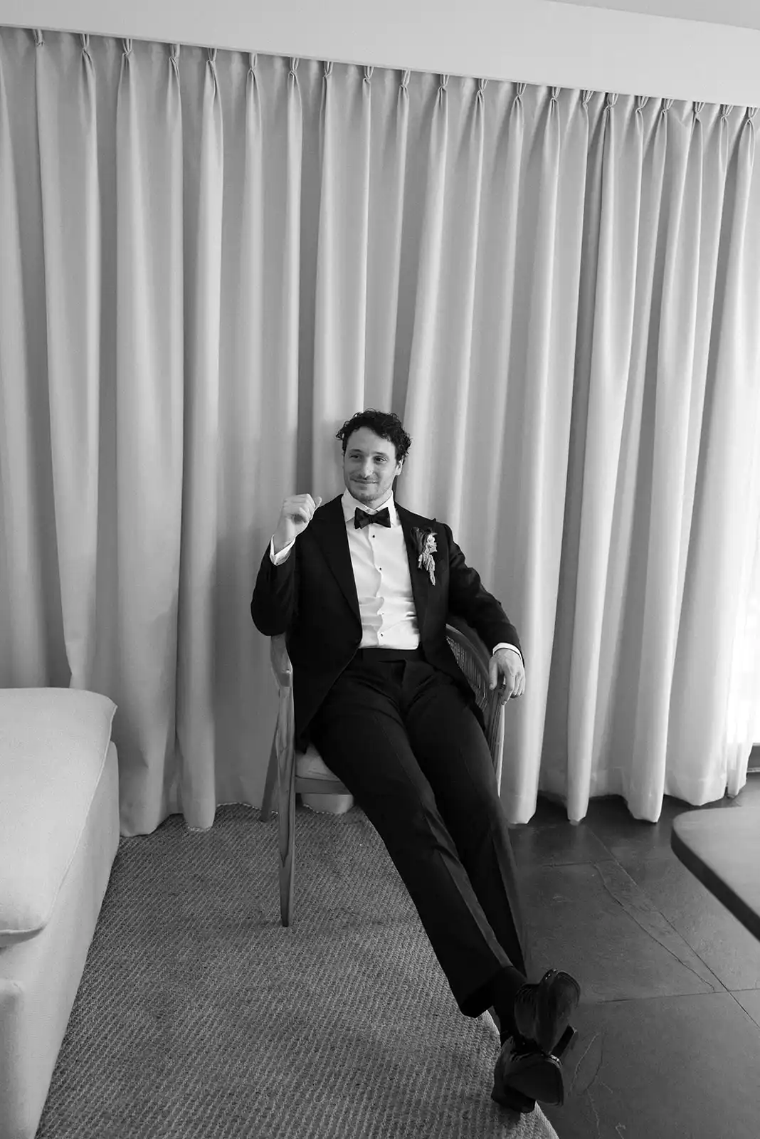 Black and white portrait of the groom seated before the ceremony